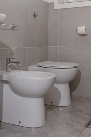 Ein Badezimmer mit Waschbecken, Bidet und Toilette.
