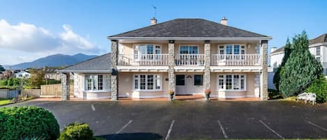 A two-story building with a central entrance, large windows, and a balcony on the upper floor.