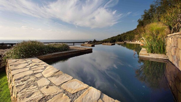 Ein Pool mit Steinverkleidung und einem weiten, klaren Blick bis zum Horizont.