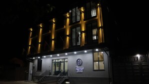 Un bâtiment sur lequel on peut lire, la nuit, une enseigne indiquant « Hôtel pour humains ».