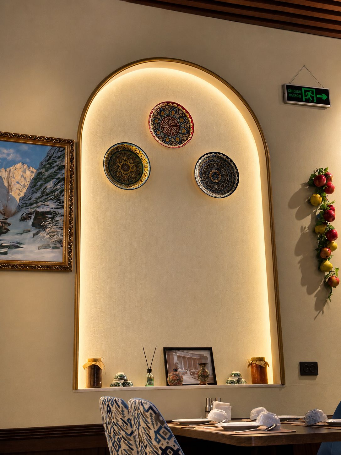 A dining area with a table, chairs, and a wall-mounted decorative panel with three circular designs.