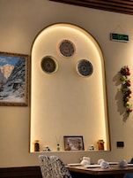 A dining area with a table, chairs, and a wall-mounted decorative panel with three circular designs.