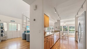 Una cocina amplia con gabinetes de madera, horno empotrado y una isla grande.