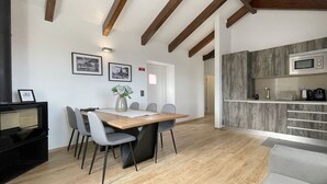 A modern kitchen with wooden cabinets and a built-in microwave. - Stylish 2 Bedroom Stone House With Stunning Views, São Jorge, Azores (Vista) (São Jorge)