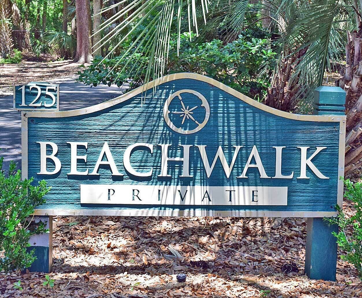 Letrero que indica 'Beachwalk Primitive' con el número '125', rodeado de árboles y follaje.