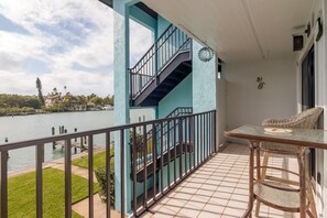Ein Balkon mit Seeblick, eine Treppe und ein Tisch mit Stühlen.