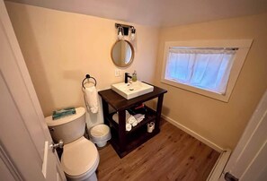 A small bathroom with a toilet, sink, and mirror.