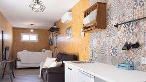 Une pièce compacte comprenant un coin cuisine, un lit et un petit espace salon.