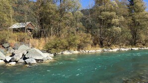 A river with clear water, surrounded by trees and rocks. - Stylish vacation apartment in an old farmhouse - south view (Kirchbach)