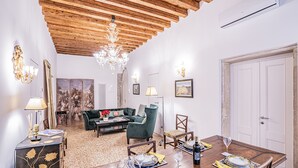 Zona pranzo con tavolo in legno apparecchiata per quattro persone, circondata da sedie.