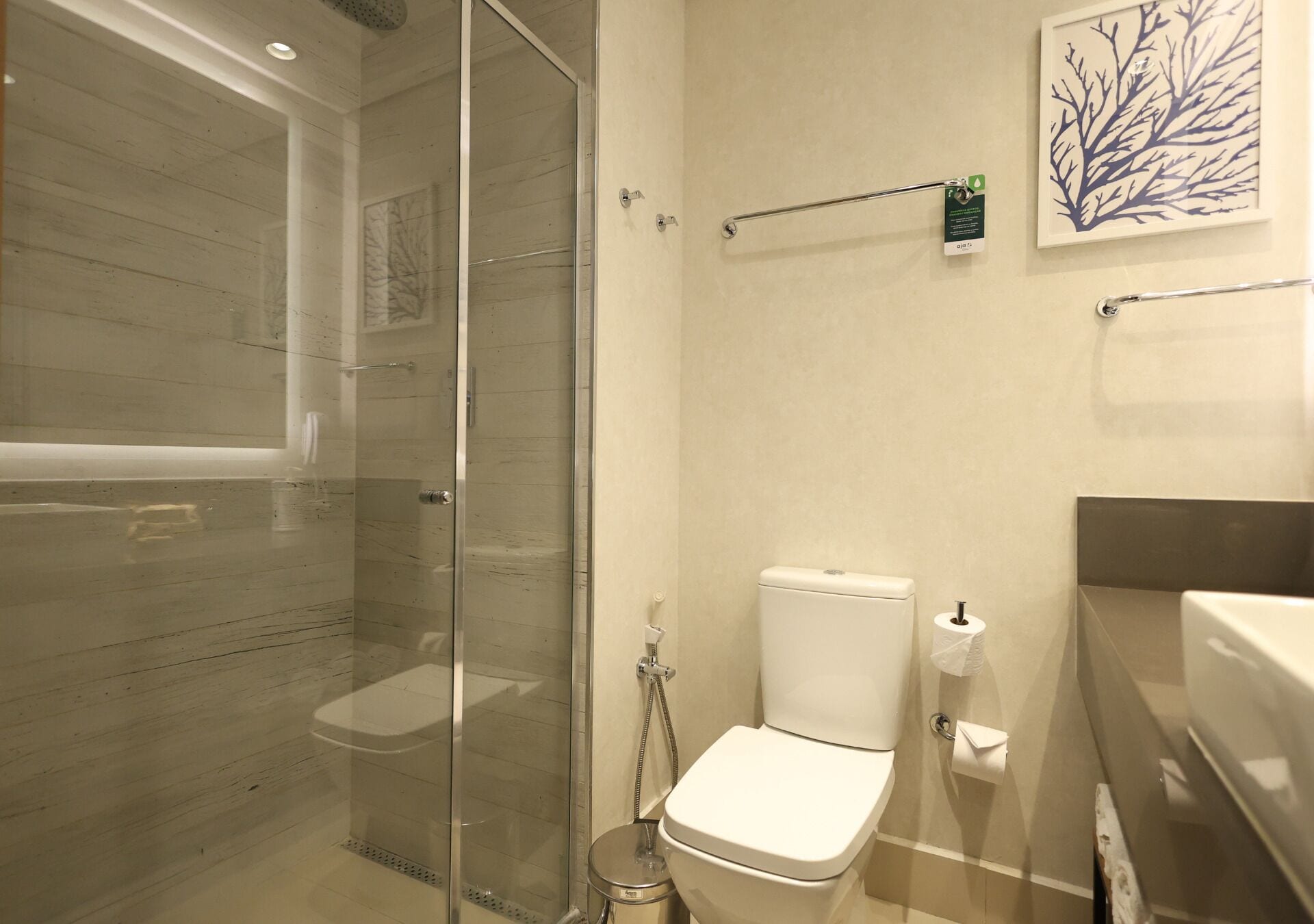 Un baño moderno con ducha de mampara de vidrio, inodoro y lavamanos.