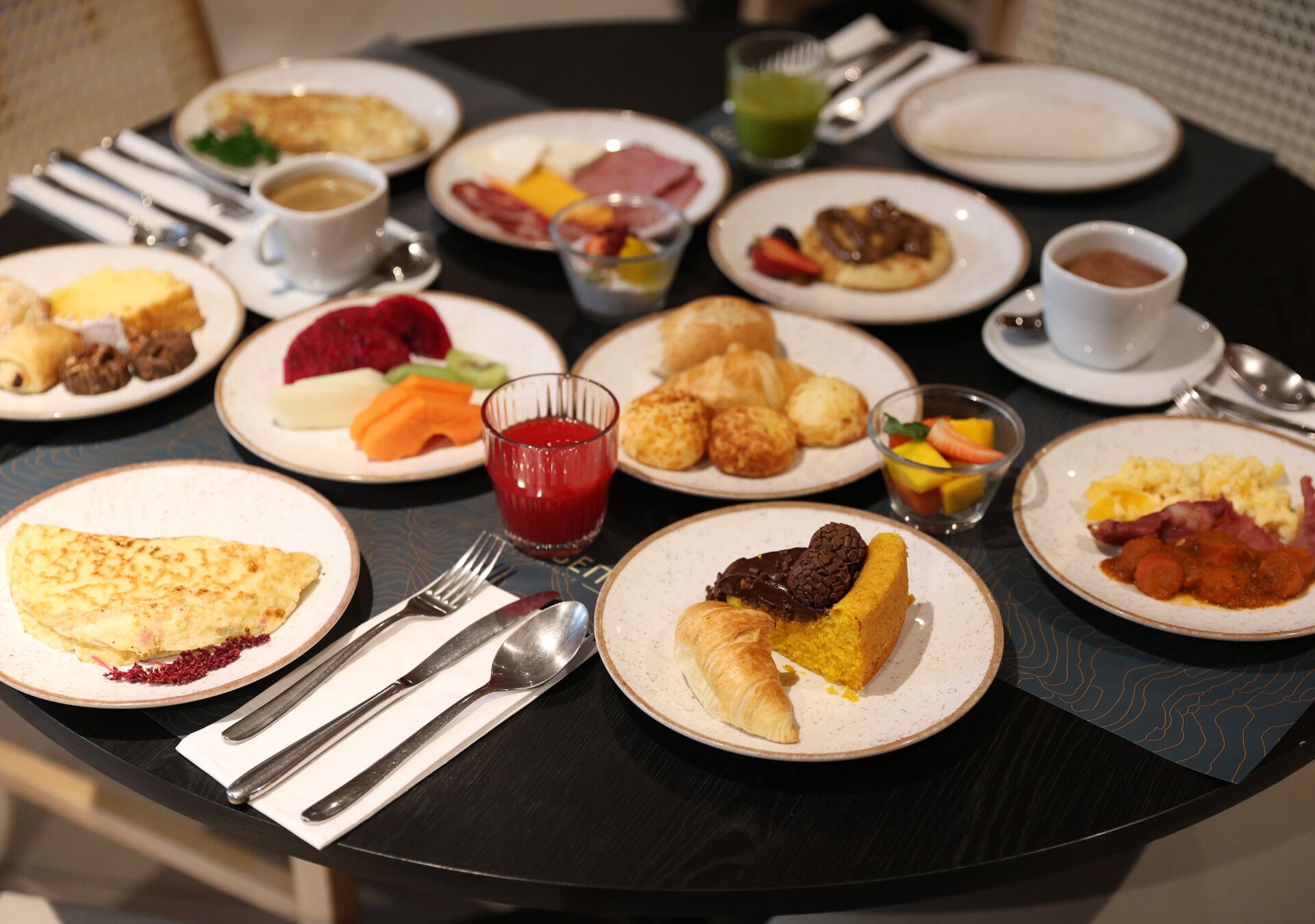 A breakfast buffet with various dishes, including eggs, pastries, and fruits.