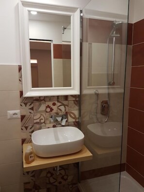 Tina con regadera, secadora de cabello, bidet, toallas 