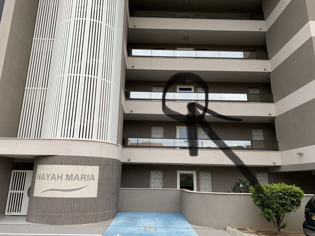 A multi-story building with a sign reading "NAYAH MARIA" on the lower level.