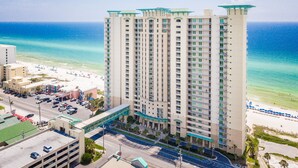 A high-rise hotel with multiple floors, a beach view, and a parking area. - Aqua 404 | Amazing Views, Incredible Amenities & Location! (Panama City Beach)