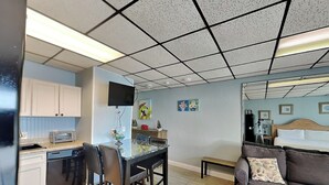 A compact living space with a kitchenette, a dining area, and a seating area with a sofa and a small table. - Continental #216, | Private Balcony and Gulf Side Pool (Panama City Beach)