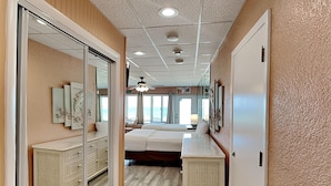 Een hotelkamer met een bed, een dressoir, een spiegel en een plafondventilator.