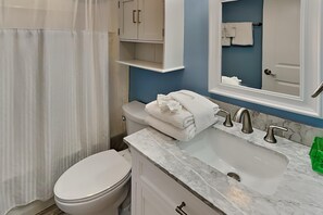 Une salle de bain avec des toilettes, un lavabo et un miroir.