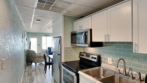 A modern kitchen with stainless steel appliances, a double sink, and a microwave. - Continental #320 | Gulf Front with Amenities! (Panama City Beach)