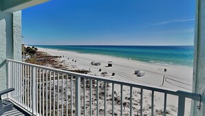 Een balkon met uitzicht op een strand en de oceaan.