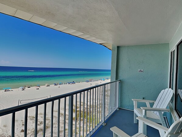 Ein Balkon mit Blick auf Strand und Meer.