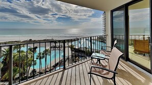 Un balcón con vistas a la playa y una piscina.