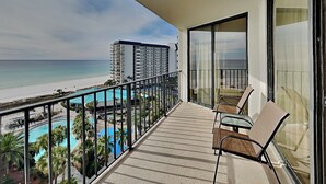 Un balcon avec vue sur une plage et une piscine.
