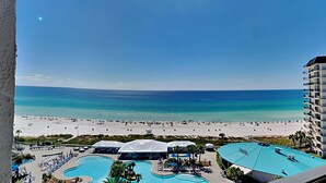 A resort with a large pool area, beach access, and a view of the ocean.