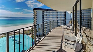 Un balcón con vista a una playa y una piscina.