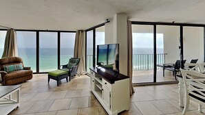 Un balcon équipé d’un téléviseur, de sièges et offrant une vue sur l’océan.