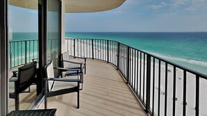 En balkon med udsigt over strand og hav.