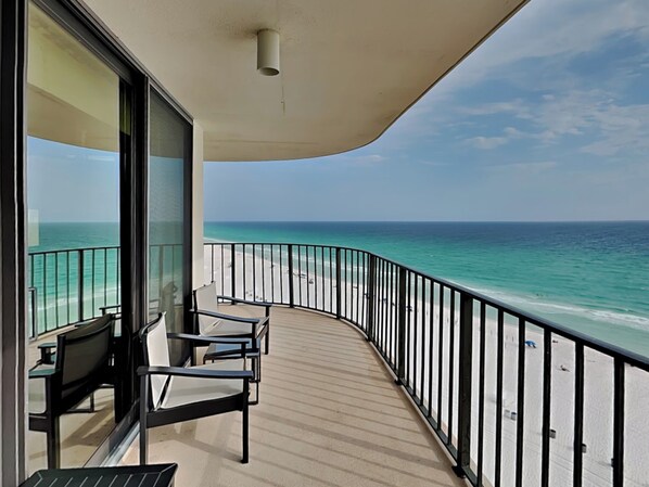 Een balkon met uitzicht op het strand en de oceaan.