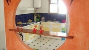 A kitchen with a round mirror, white cabinets, and blue tiles. - Maine-Charming Creole villa at the gateway to the south of Martinique. (sainte Anne)