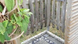 A wooden fence with a tiled walkway leading to a door. - Maine-Charming Creole villa at the gateway to the south of Martinique. (sainte Anne)