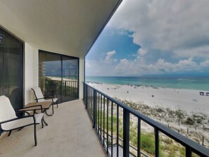 A balcony with a view of a beach and ocean.