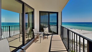 A balcony with a view of the beach and ocean.