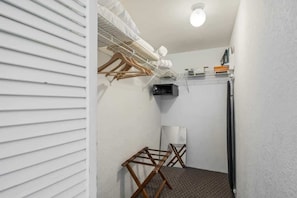 A compact utility room with a drying rack, a small heater, and a microwave.