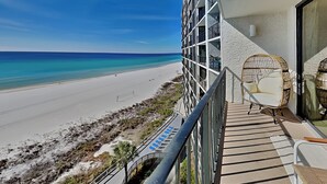 A balcony with a view of a beach and ocean.