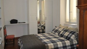 Une chambre à coucher avec un lit, une chaise, une armoire et un miroir.