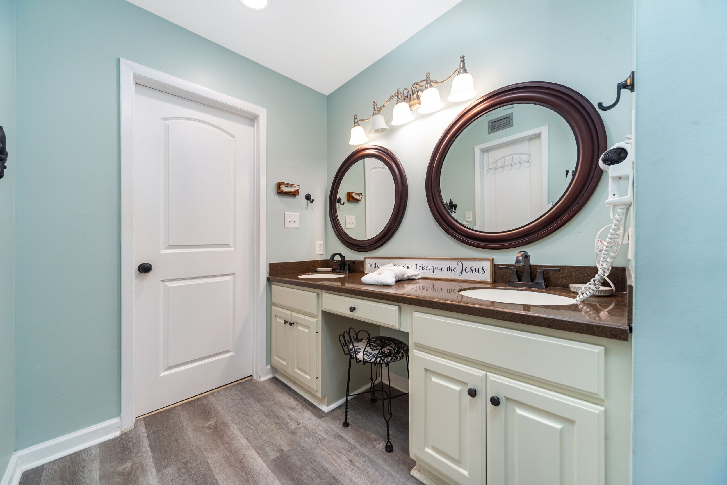 Une salle de bain avec deux lavabos, un meuble-lavabo, un miroir et un porte-serviettes.