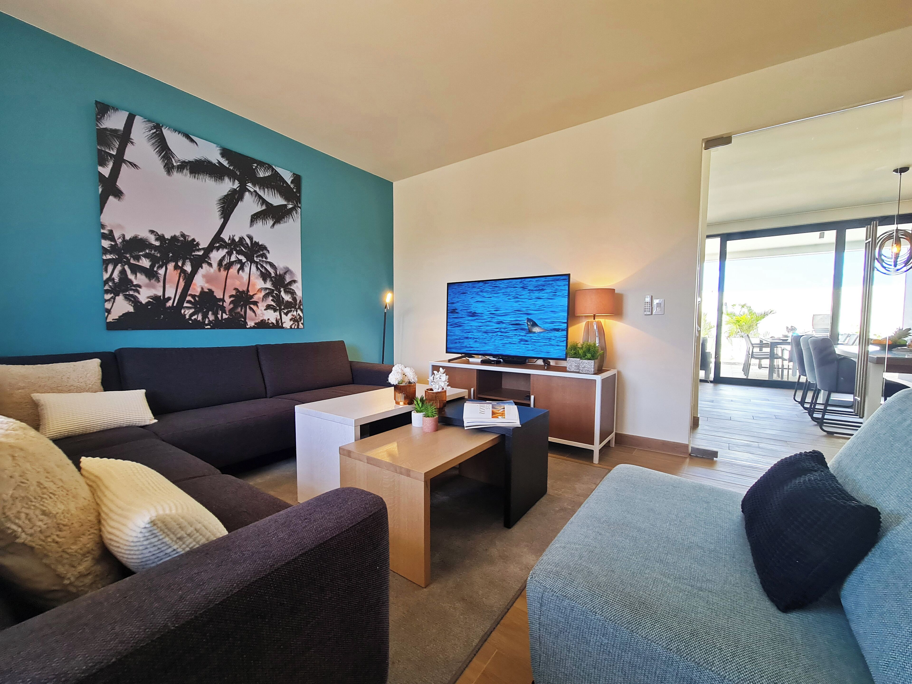 A modern living room with a sofa, coffee table, and a TV.