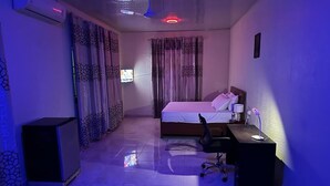 Ein Hotelzimmer mit Bett, Schreibtisch, Stuhl und Fernseher.