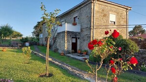 A stone building with a white upper section, a door, and a small window. - Rural farm - Queen room with breakfast (Viana do Castelo)