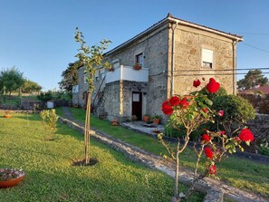 A stone building with a white upper section, a door, and a small window.