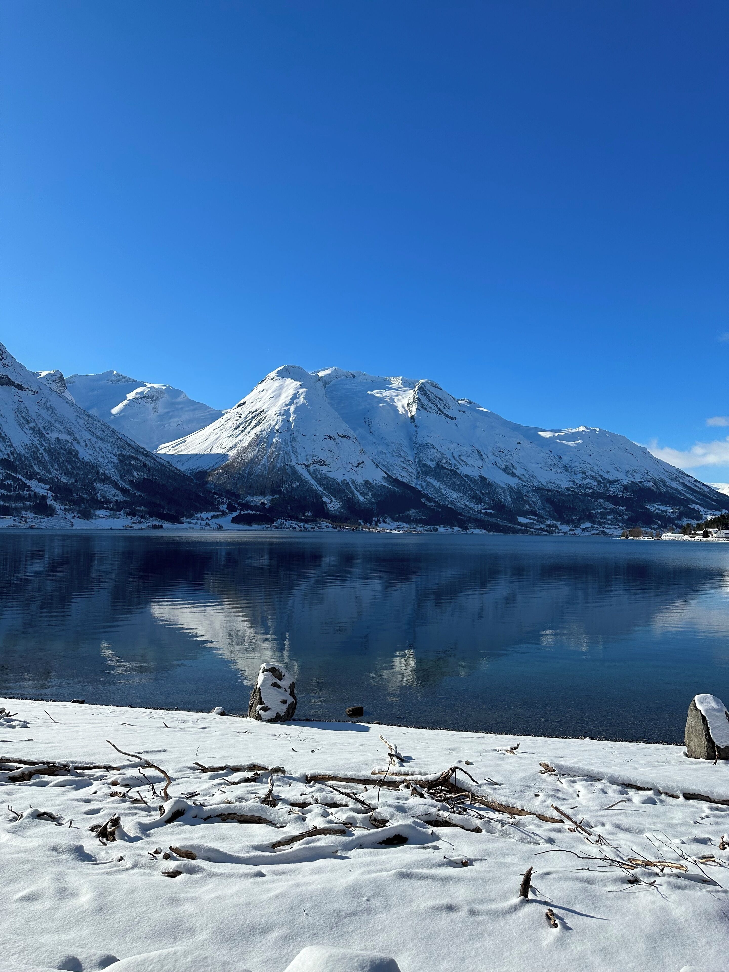 A snow-covered lake with mountains in the background.