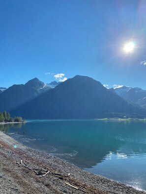 A clear view of a mountain range with a lake in the foreground.