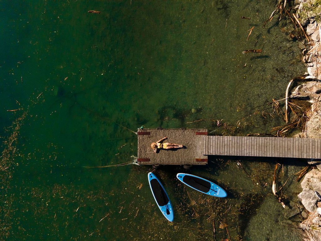 Un muelle con una persona y dos kayaks.