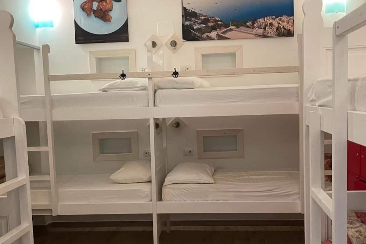 A bunk bed room with a view of a coastal town.