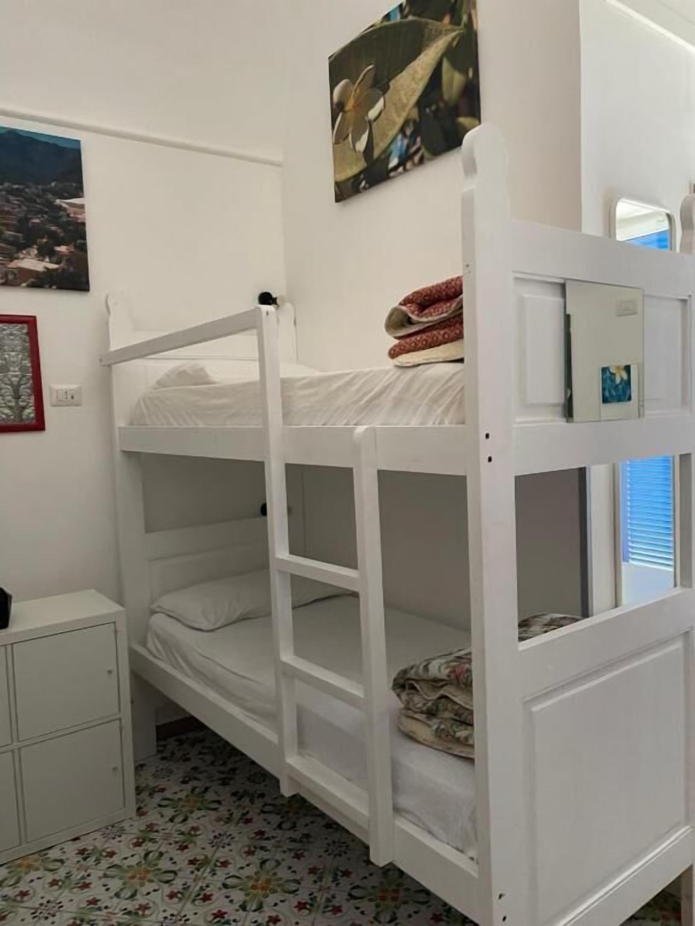 A bunk bed with a lower bunk and a small cabinet below it.