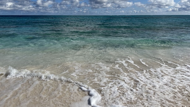 Una playa con agua turquesa cristalina y arena blanca.